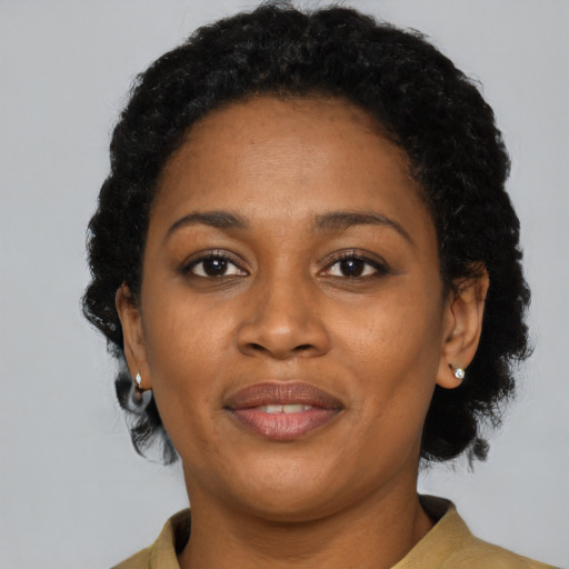 Joyful black adult female with short  black hair and brown eyes