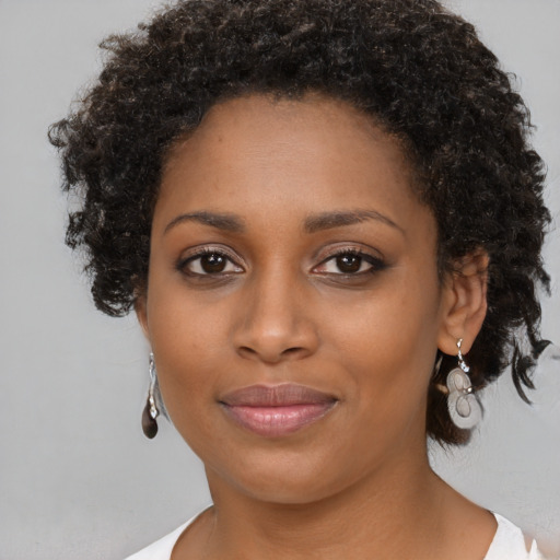 Joyful black young-adult female with medium  brown hair and brown eyes