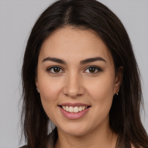 Joyful white young-adult female with long  brown hair and brown eyes