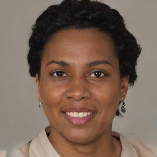 Joyful black adult female with short  black hair and brown eyes
