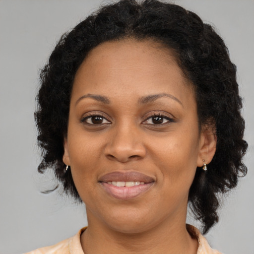 Joyful black adult female with long  brown hair and brown eyes