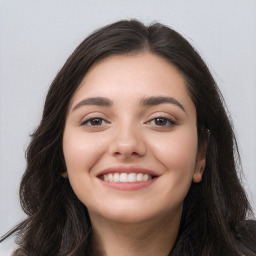 Joyful white young-adult female with long  black hair and brown eyes