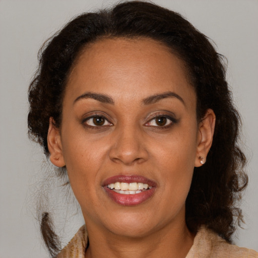 Joyful latino adult female with medium  brown hair and brown eyes