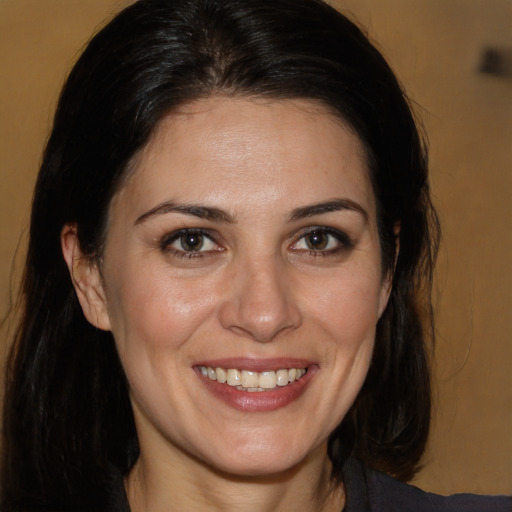 Joyful white adult female with long  brown hair and brown eyes