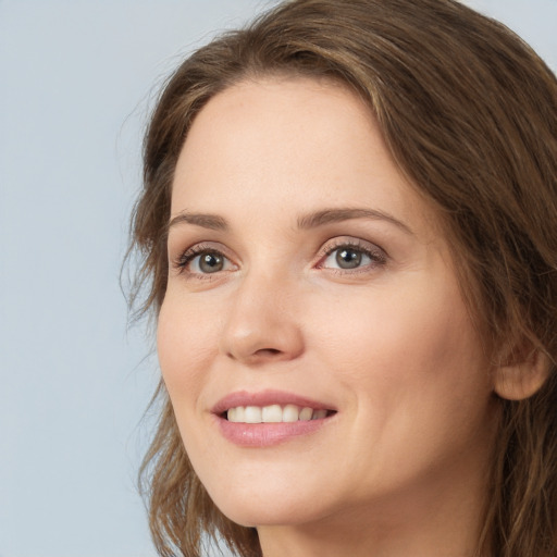 Joyful white young-adult female with long  brown hair and green eyes