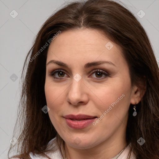 Joyful white adult female with long  brown hair and brown eyes