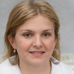 Joyful white young-adult female with medium  brown hair and grey eyes