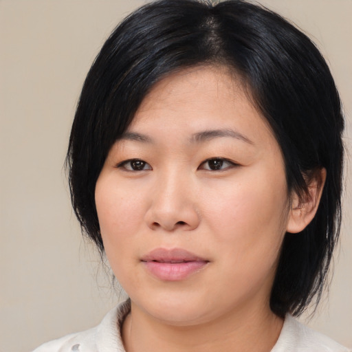 Joyful asian young-adult female with medium  black hair and brown eyes
