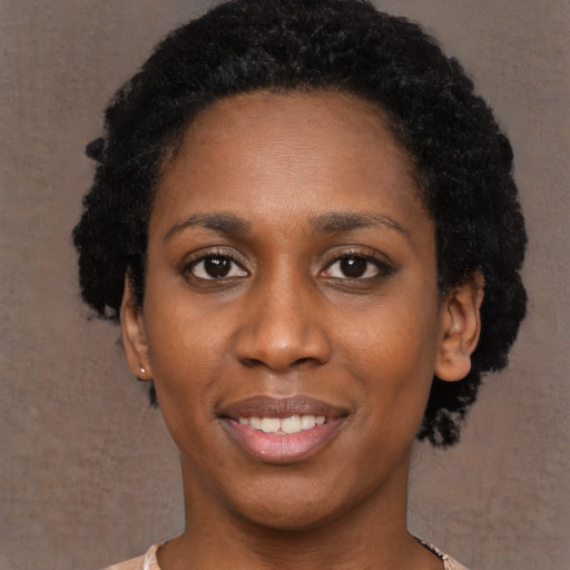 Joyful black young-adult female with short  black hair and brown eyes