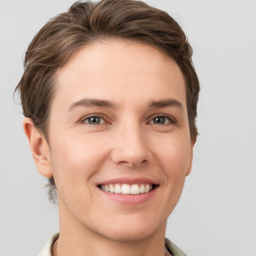 Joyful white young-adult female with short  brown hair and grey eyes