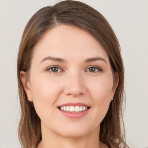 Joyful white young-adult female with long  brown hair and grey eyes