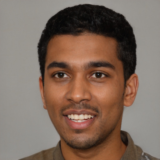 Joyful black young-adult male with short  black hair and brown eyes
