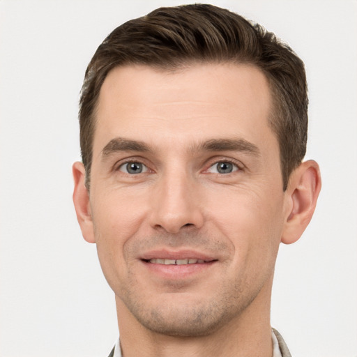 Joyful white young-adult male with short  brown hair and grey eyes