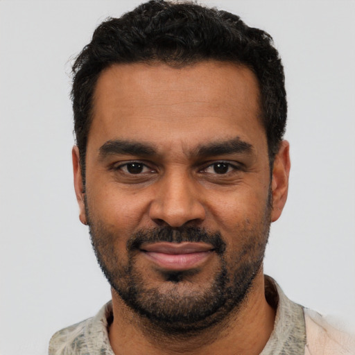 Joyful black young-adult male with short  black hair and brown eyes
