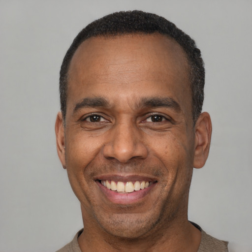 Joyful latino adult male with short  black hair and brown eyes