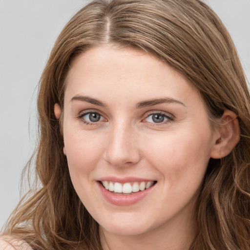 Joyful white young-adult female with long  brown hair and grey eyes