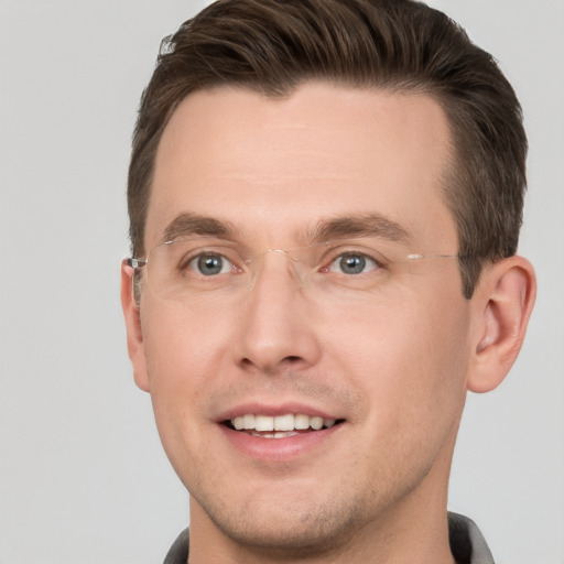 Joyful white young-adult male with short  brown hair and grey eyes