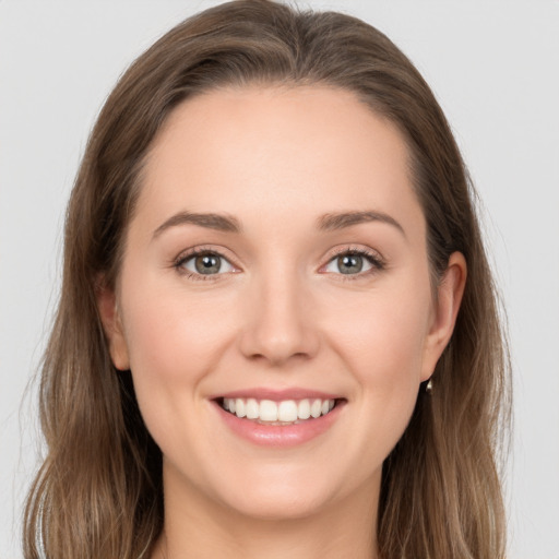 Joyful white young-adult female with long  brown hair and grey eyes