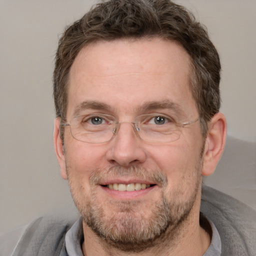 Joyful white adult male with short  brown hair and grey eyes