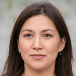 Joyful white adult female with long  brown hair and brown eyes