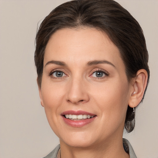 Joyful white adult female with medium  brown hair and grey eyes