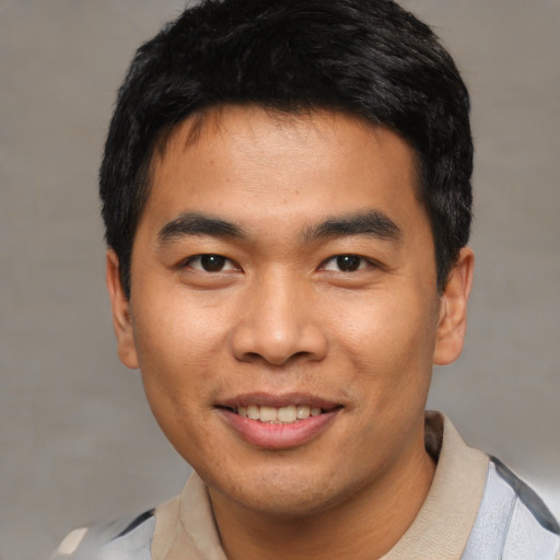 Joyful asian young-adult male with short  black hair and brown eyes