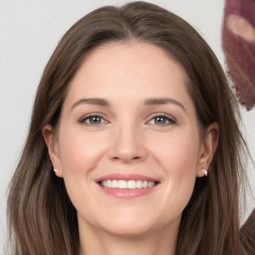 Joyful white young-adult female with long  brown hair and grey eyes