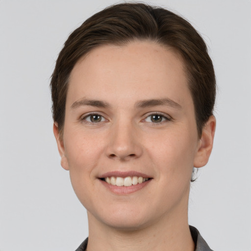 Joyful white young-adult female with short  brown hair and grey eyes