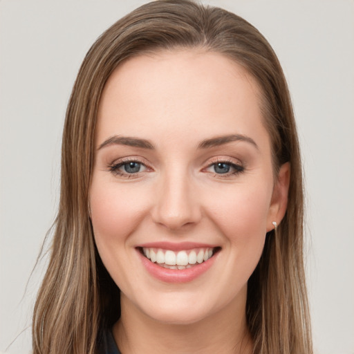 Joyful white young-adult female with long  brown hair and green eyes