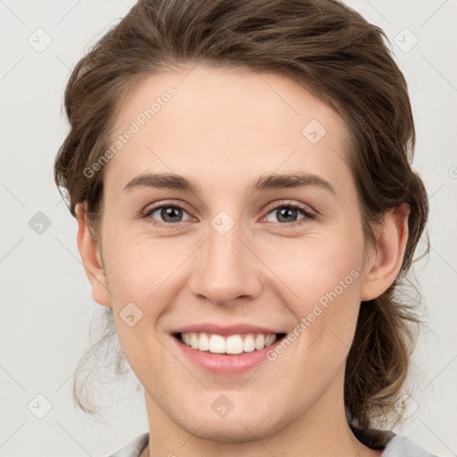 Joyful white young-adult female with medium  brown hair and grey eyes