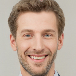 Joyful white young-adult male with short  brown hair and grey eyes