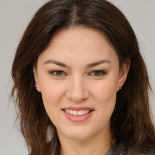 Joyful white young-adult female with long  brown hair and brown eyes