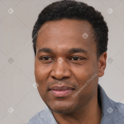 Joyful black adult male with short  black hair and brown eyes