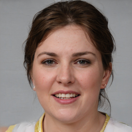 Joyful white young-adult female with medium  brown hair and blue eyes