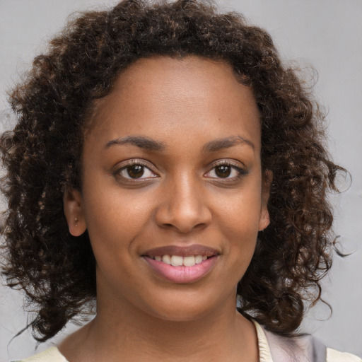 Joyful black young-adult female with medium  brown hair and brown eyes