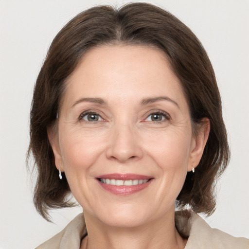 Joyful white adult female with medium  brown hair and grey eyes