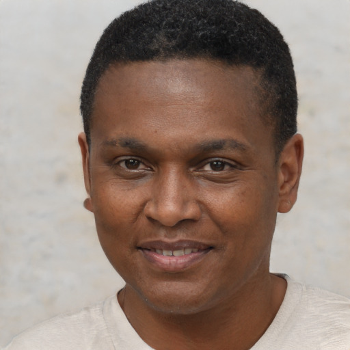 Joyful black young-adult male with short  black hair and brown eyes