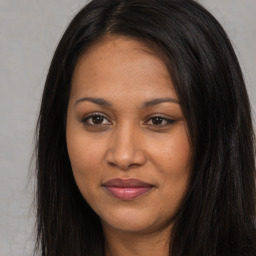 Joyful black young-adult female with long  brown hair and brown eyes