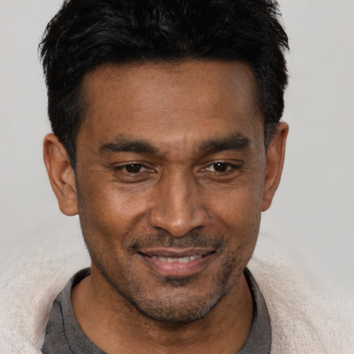 Joyful black adult male with short  black hair and brown eyes