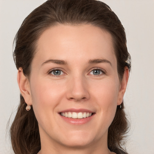 Joyful white young-adult female with medium  brown hair and grey eyes