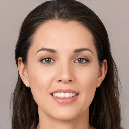 Joyful white young-adult female with long  brown hair and brown eyes