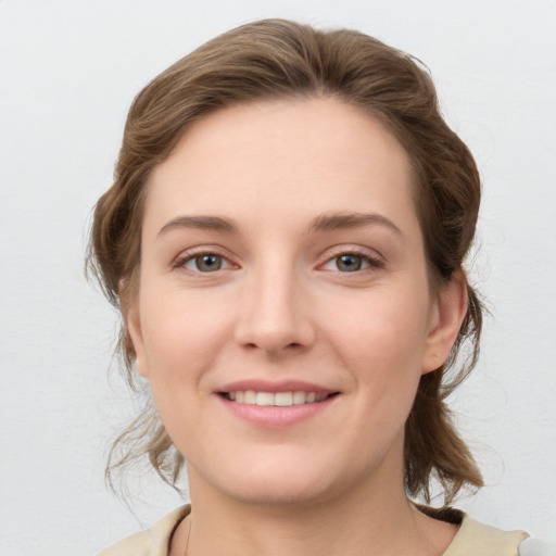 Joyful white young-adult female with medium  brown hair and grey eyes