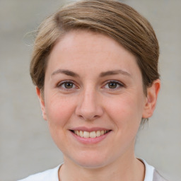 Joyful white young-adult female with short  brown hair and grey eyes