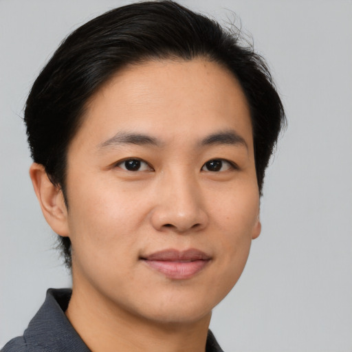 Joyful asian young-adult male with short  brown hair and brown eyes