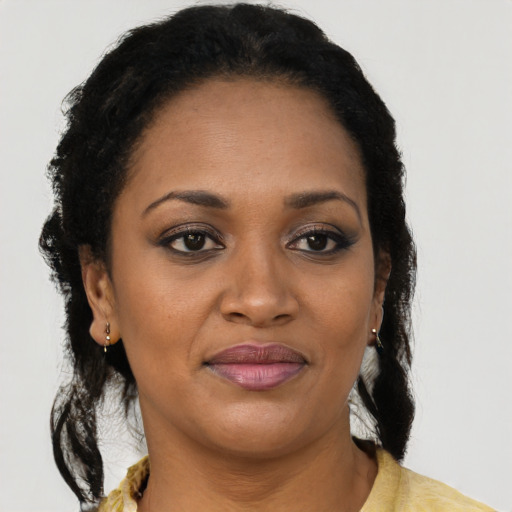 Joyful black adult female with long  brown hair and brown eyes