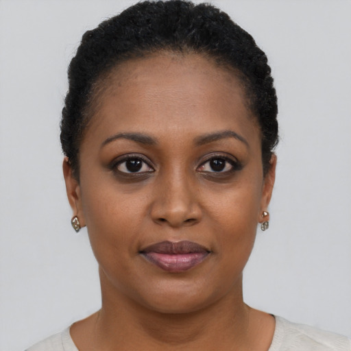 Joyful black young-adult female with short  black hair and brown eyes