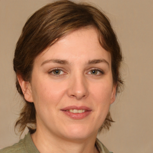 Joyful white young-adult female with medium  brown hair and green eyes