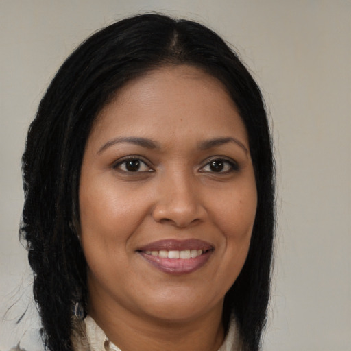 Joyful black young-adult female with long  brown hair and brown eyes