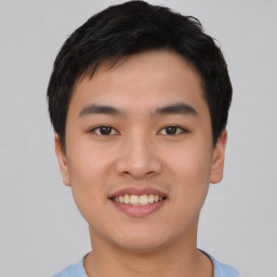 Joyful asian young-adult male with short  black hair and brown eyes