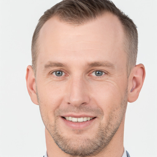 Joyful white young-adult male with short  brown hair and grey eyes